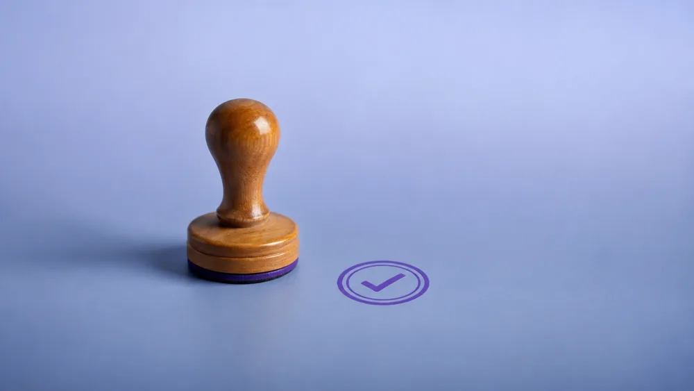 A rubber stamp beside the violet seal it has pressed, marking Vigor's VAT and tax articles